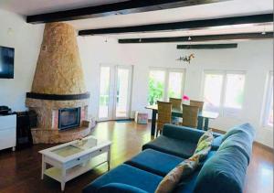 a living room with a blue couch and a fireplace at Villa Sol e Mar in Portimão