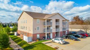 een appartementencomplex met auto's geparkeerd op een parkeerplaats bij ConTemporary Stay in Central Peoria in Peoria