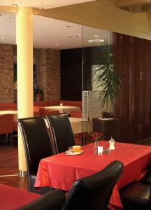 a dining room with a red table and black chairs at Kurhotel Bad Zell in Bad Zell