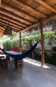 a hammock on a patio under a wooden roof at CAMPO y PLAYA OLON HACIENDAS in Olón