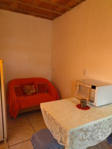a living room with a microwave and a couch at Kitnet SIMIROMBA in Pelotas