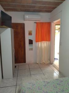 um quarto com uma porta e um quarto com uma cama em Kitnet SIMIROMBA em Pelotas