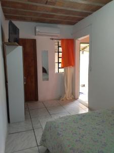 a bedroom with a bed and a door with a window at Kitnet SIMIROMBA in Pelotas