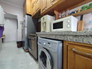 a kitchen with a washing machine and a microwave at appartement centre in Casablanca