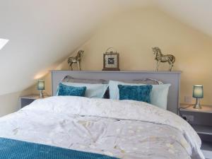 a bedroom with a white bed with blue pillows at Uk7384 - The Hayloft in Newmilns