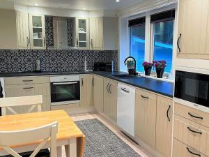 een keuken met witte kasten en een houten tafel bij Holiday home PRÄSSEBO II in Eckerud