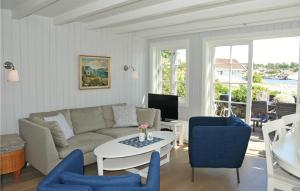 sala de estar con sofá, mesa y sillas en Stunning Home In Flekkery With Kitchen, en Møvik