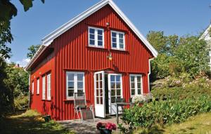 una casa roja con una puerta blanca y ventanas en Stunning Home In Flekkery With Kitchen, en Møvik