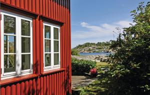 una casa rossa con due finestre sul lato di Holiday Home Flekkerøy Paulen Ii a Møvik