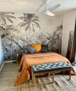Schlafzimmer mit einem Bett und einem Wandbild von Palmen in der Unterkunft Colors by MG2 in Saint Martin