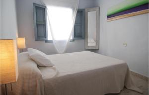 a white bedroom with a bed and two windows at Stunning Home In Frigiliana With 2 Bedrooms And Wifi in Frigiliana