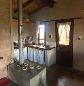 eine Küche mit einem Herd mit Spüle und einem Fenster in der Unterkunft Ranchos en Payogasta - Cachi in Payogasta