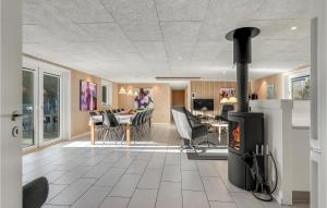 a living room with a fireplace and a dining room at Lovely Home In Ringkøbing With Sauna in Søndervig