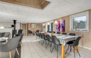 a dining room with a long table and chairs at Lovely Home In Ringkøbing With Sauna in Søndervig