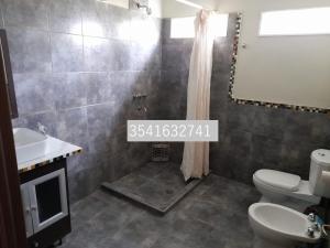 W łazience znajduje się umywalka, toaleta i lustro. w obiekcie Aires Casas de campo w mieście Villa Santa Cruz del Lago