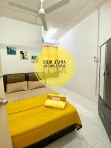 a bedroom with a yellow bed in a room at LH Homestay Bandar Utama Gua Musang in Gua Musang