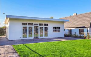 a white house with a grass yard in front of it at Rottummeroog in Den Oever