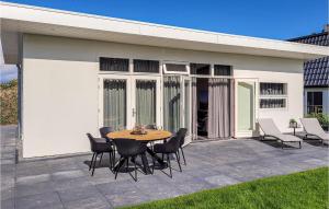 a patio with a table and chairs in front of a building at Rottummeroog in Den Oever