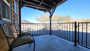 a porch with two chairs and a balcony with a view at Panamint Springs Motel & Tents in Panamint Springs