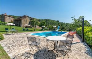 a patio with a table and chairs next to a pool at Gorgeous Apartment In Cortona Ar With Wifi in Poggioni