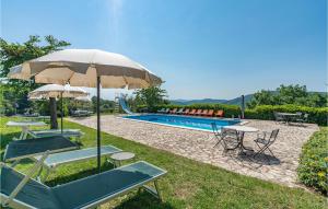 a pool with tables and chairs and an umbrella at Gorgeous Apartment In Cortona Ar With Wifi in Poggioni
