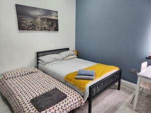 ロンドンにあるDodi Apartmentのベッドルーム1室(ツインベッド1台、オットマン付)