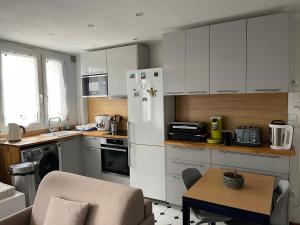 白鴿城的住宿－民居舒適小屋民宿，厨房配有白色橱柜和白色冰箱。