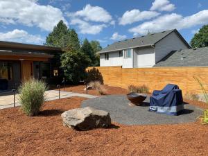 a garden with a rock and a fence at Hilltop Hideaway, Pacific Northwest charm & luxury in Portland