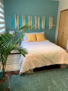 1 dormitorio con 1 cama y un estante de tablas de surf en Hilltop Hideaway, Pacific Northwest charm & luxury, en Portland