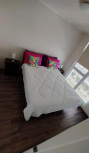 Un dormitorio con una cama blanca con almohadas. en 408/ Precioso apartamento 1D+1B /(3 camas)/ JUMBO+CENTRO 5 MIN, en Puerto Montt