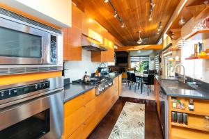 una cocina con armarios de madera y electrodomésticos de acero inoxidable en Hilltop Hideaway, Pacific Northwest charm & luxury, en Portland