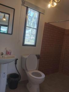 een badkamer met een toilet, een wastafel en een raam bij Nice Home Stay @Samroiyot in Sam Roi Yot