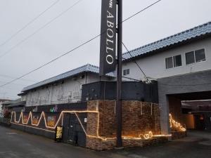 un bâtiment avec une enseigne sur le côté dans l'établissement Abollo Odawara, à Odawara