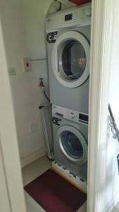 a washer and dryer in a small room at Harloes Luxury Suite - Kingston Jamaica in Kingston