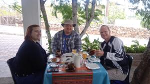 un grupo de personas sentadas alrededor de una mesa en Hostal Cabañas Don Jorge, en Puerto Baquerizo Moreno