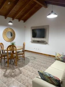 sala de estar con mesa y TV en La Piccolina en Tunuyán