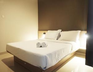 a bedroom with a bed with two towels on it at Kanna Stay in Semolowaru