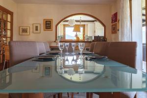een glazen tafel in een eetkamer met stoelen bij La villa panoramique in Sévrier