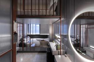ein Bad mit einem Bett, einem Waschbecken und einem Spiegel in der Unterkunft NOA Hotel & Coffee Xiamen in Xiamen