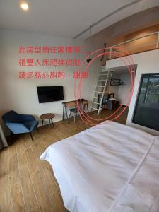 a bedroom with a white bed and a red hose at 埔里隱巷人文行旅民宿 in Puli
