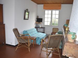 ein Wohnzimmer mit Stühlen, einem Tisch und einem Fenster in der Unterkunft Maison La Tranche-sur-Mer, 3 pièces, 4 personnes - FR-1-22-214 in La Tranche-sur-Mer
