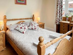a bedroom with a wooden bed with pillows on it at Station House in Hornsea