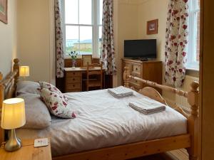 a bedroom with a bed with a television and a table at Station House in Hornsea