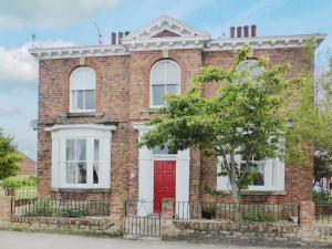 a red brick house with a red door at Station House in Hornsea