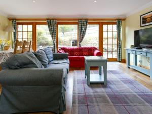 a living room with a couch and a table at The Barn - S4593 in Lochearnhead