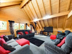 a living room with couches and a flat screen tv at Alpine Lodge in Pentney