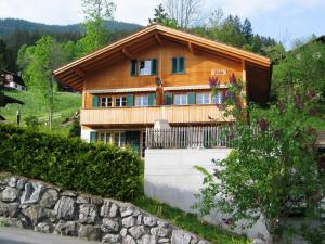 a house in the mountains with a stone wall at Apartment Kiwi links - GRIWA RENT AG in Grindelwald