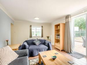 uma sala de estar com um sofá e uma mesa em Managers Cottage em Loddon