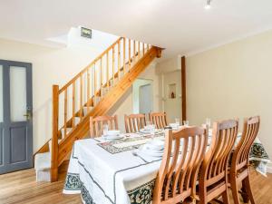uma sala de jantar com uma mesa e uma escada em Managers Cottage em Loddon