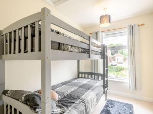 a bedroom with bunk beds and a window at Managers Cottage in Loddon